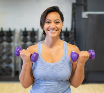 Fitness member curling small hand weights.