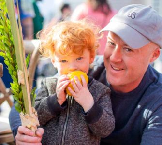 Man with small boy holding yellow fruit