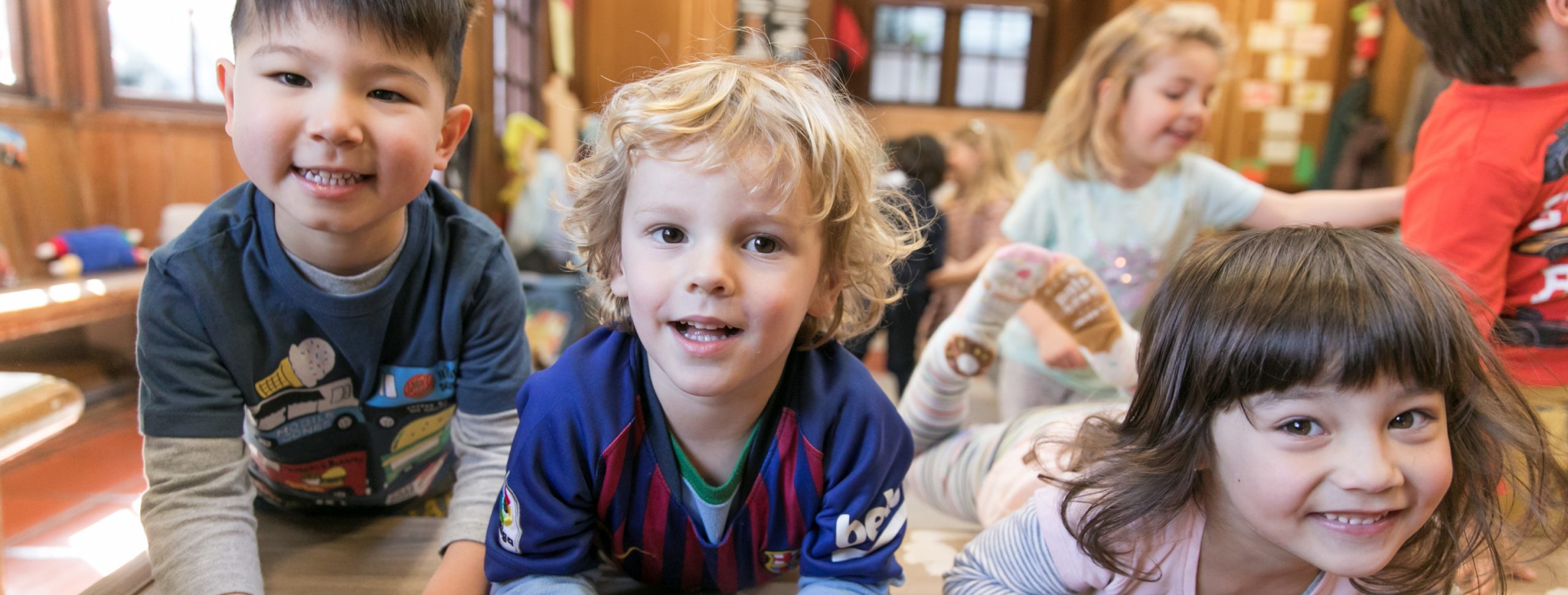 Children sitting on the floor having a good time and smiling at the camera