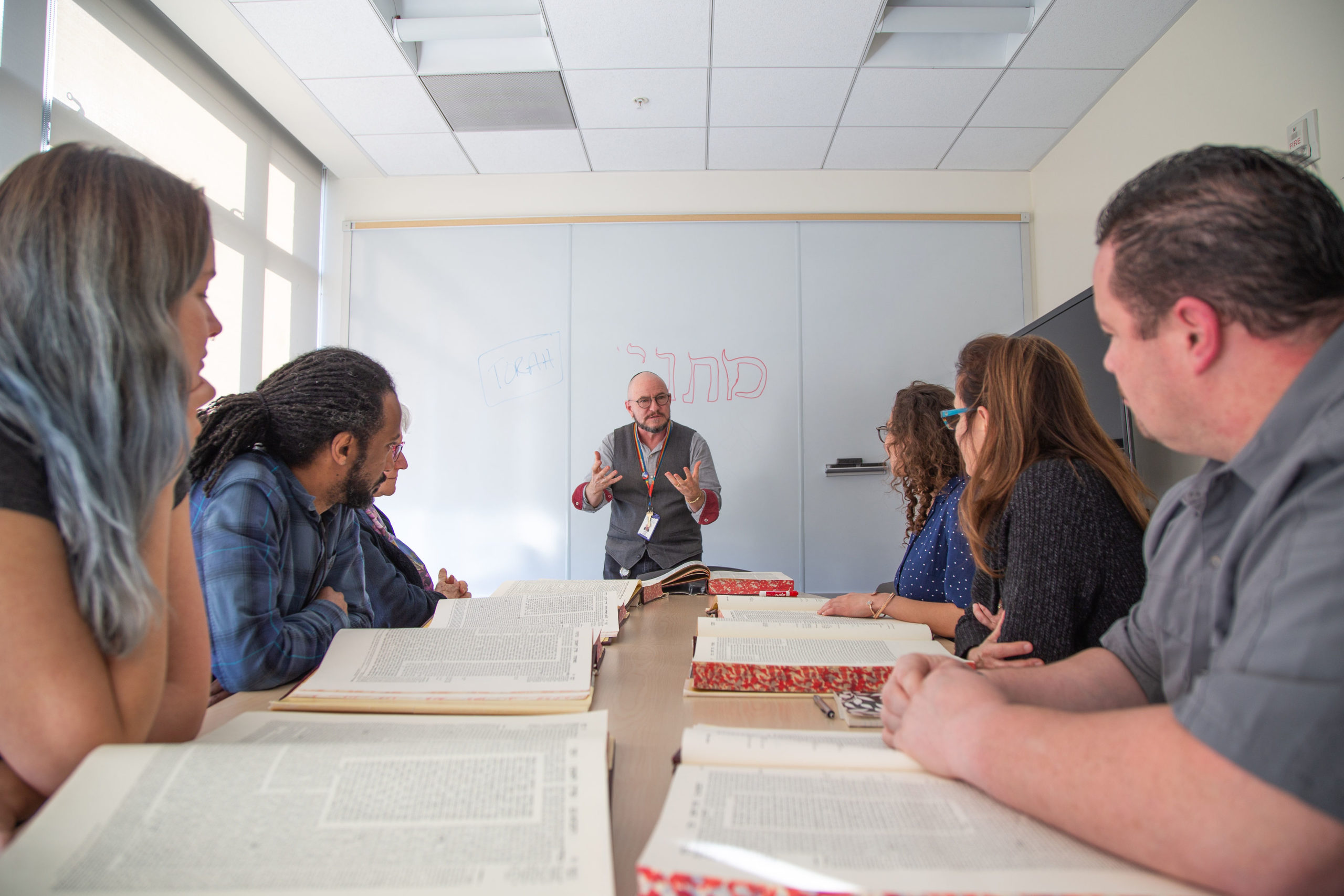 Class sitting at a table with books open