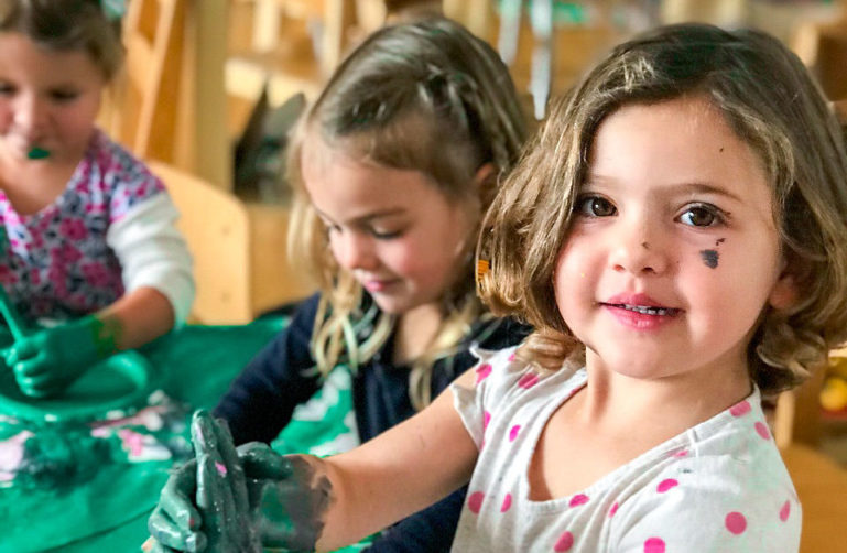 Helen Diller Family Preschool kids painting in the art studio.