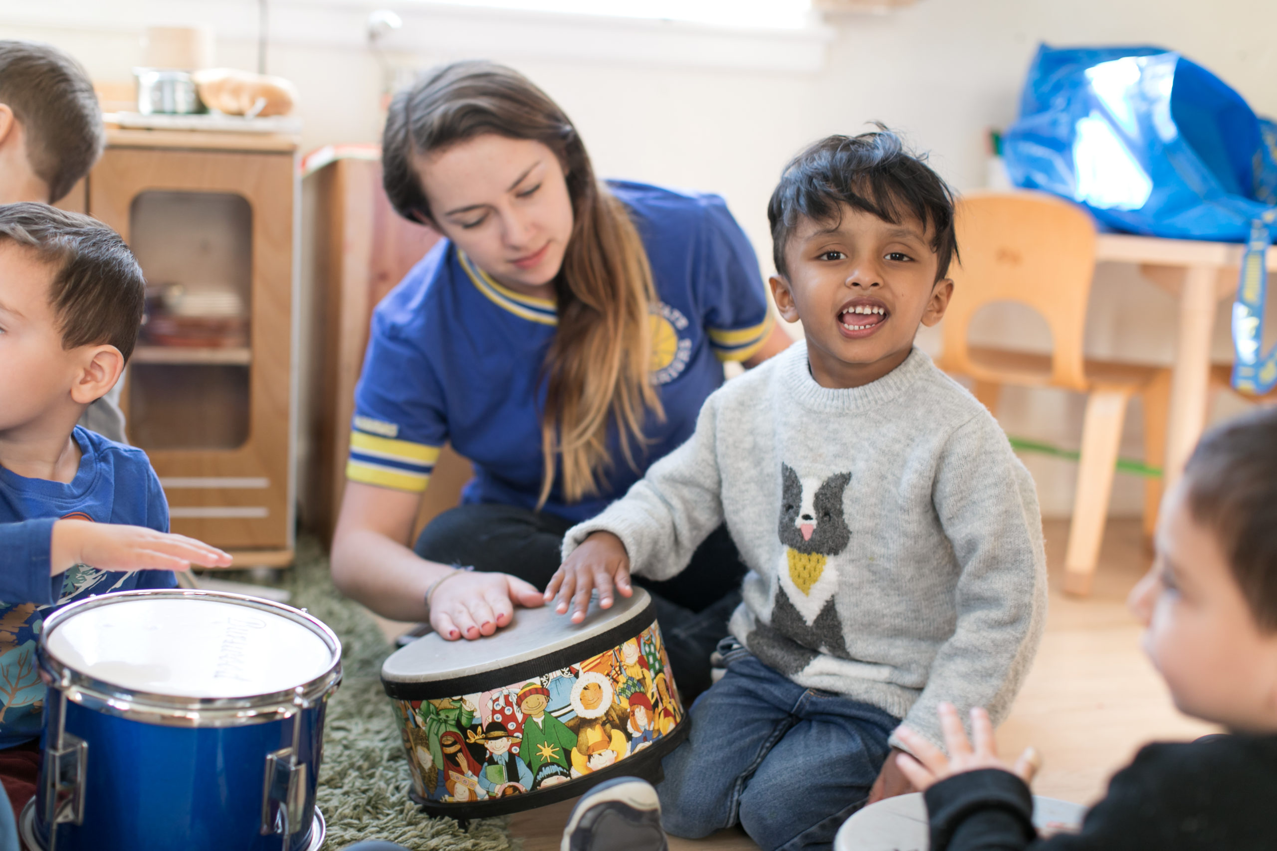 Boy and teacher play with drum