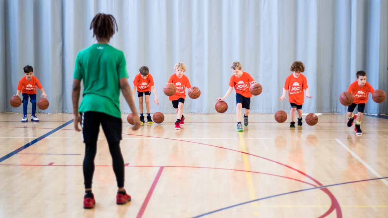 Youth basketball group lines up to practice dribbling