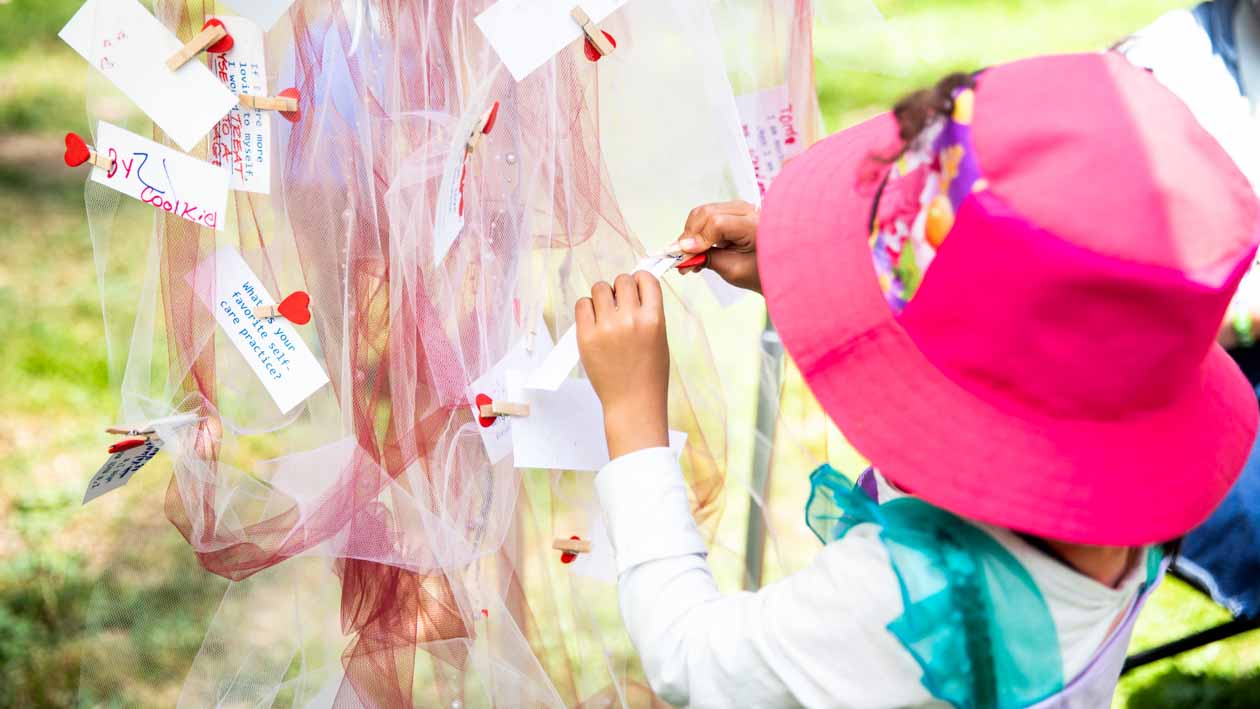 Young child clips message to hanging chiffon