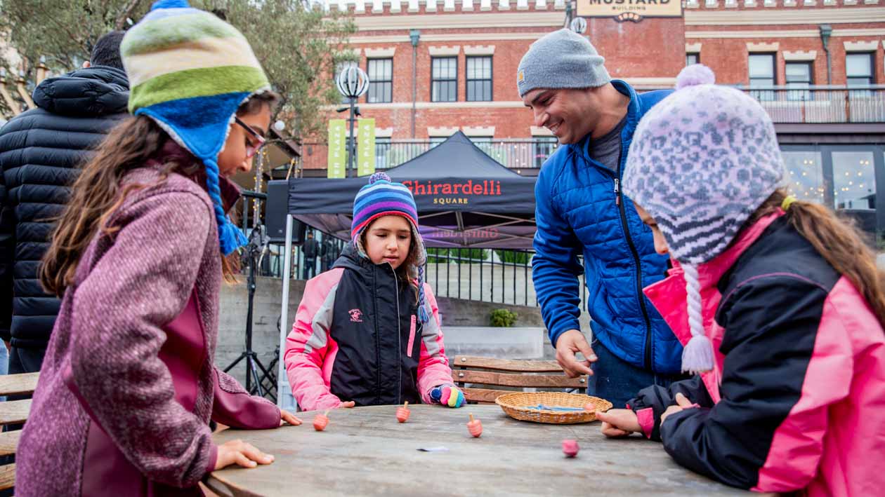 Man and children play game at Ghirardelli popup