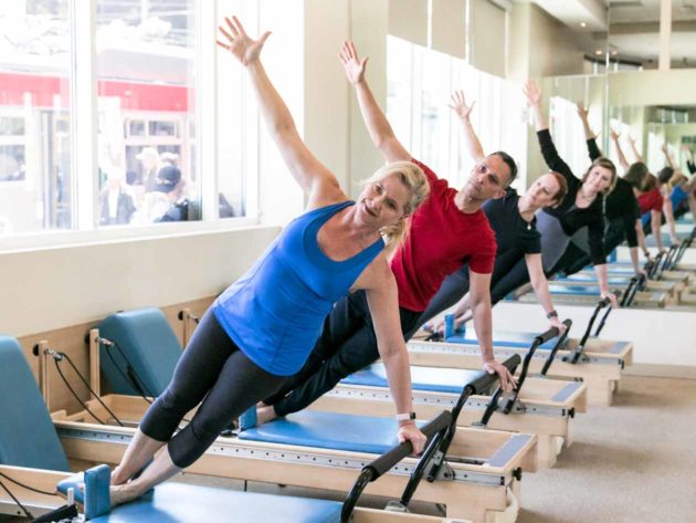 Pilates group poses on reformers