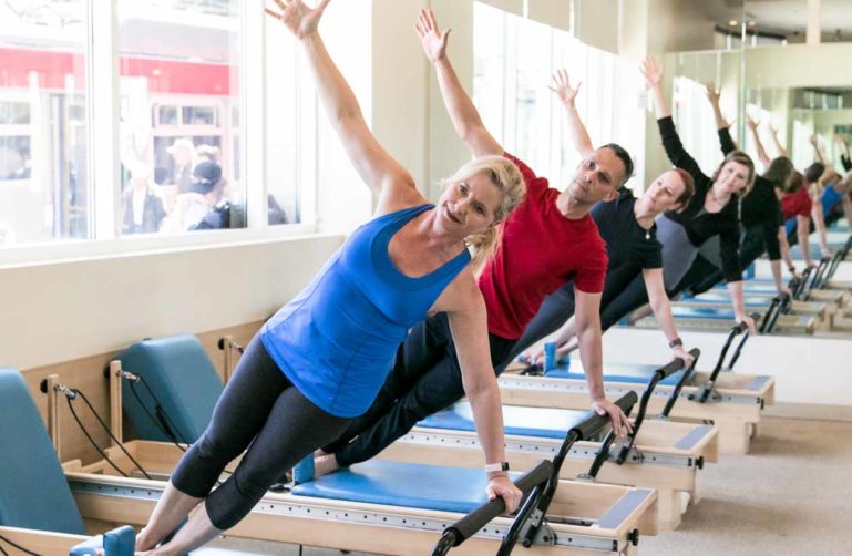 Pilates group poses on reformers
