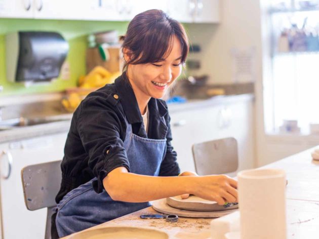 Smiling woman works on ceramics project