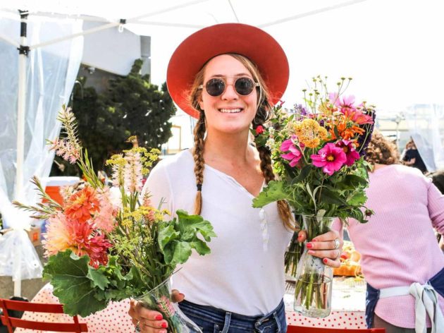 Woman in sunglasses holds two flower bouquets