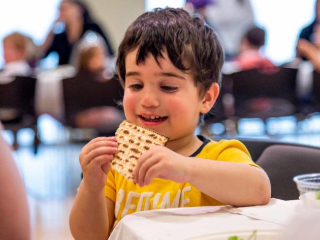 Young boy eats bread at Passover gathering