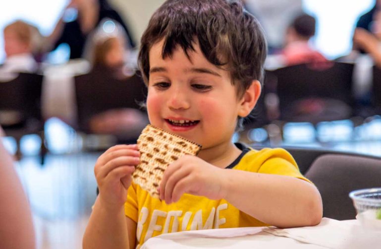 Young boy eats bread at Passover gathering