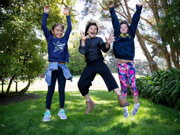 Three girls jumping in the park