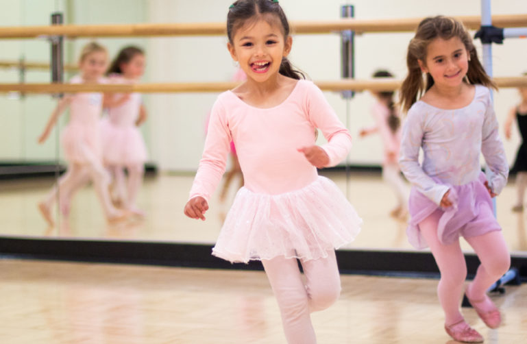 Little girls smiling and dancing in the studio.