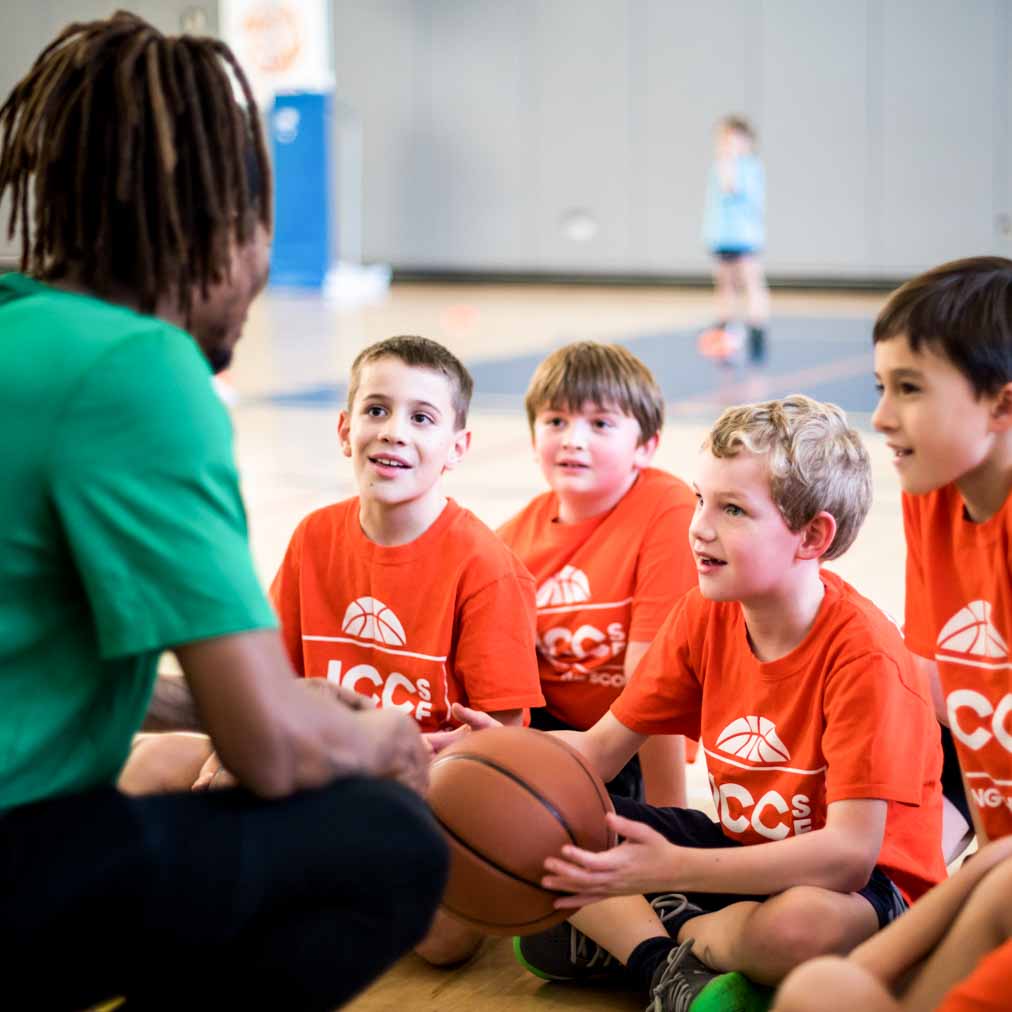 Youth basketball coach chats with kids