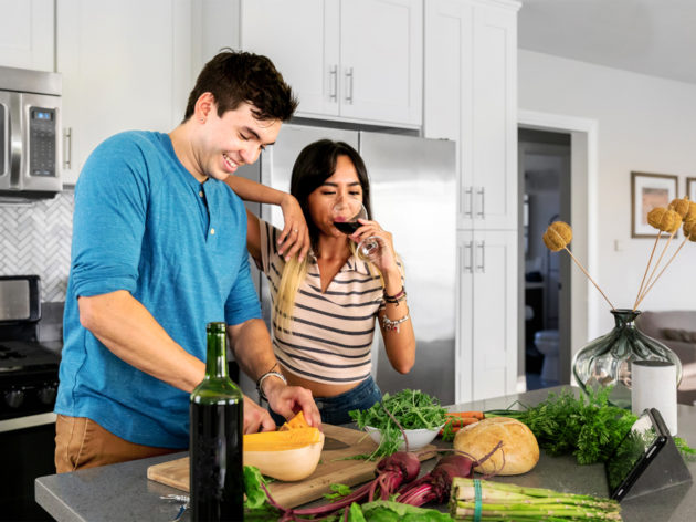 Couple cooking and drinking wine in the kitchen