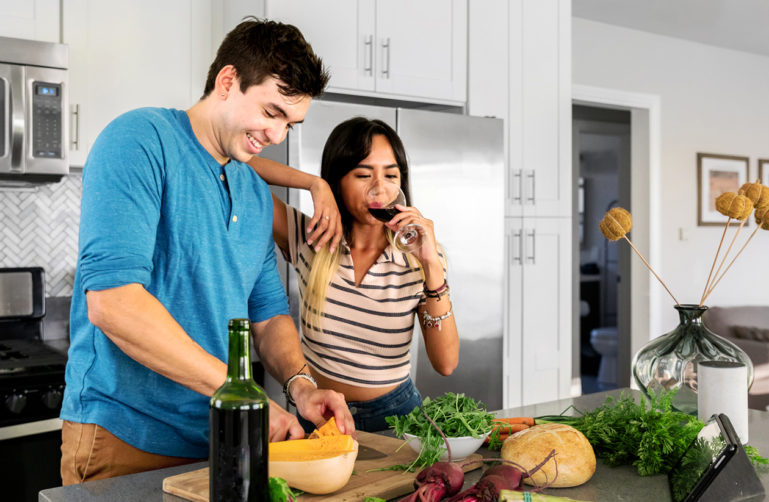 Couple cooking and drinking wine in the kitchen