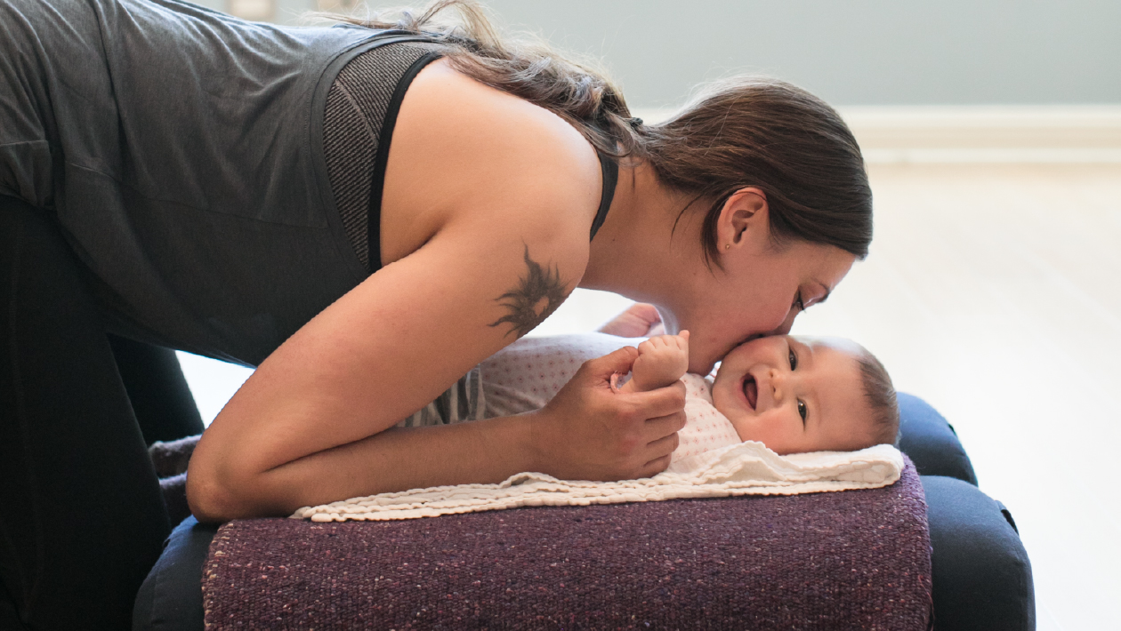 Mother nuzzling baby during yoga class. 
