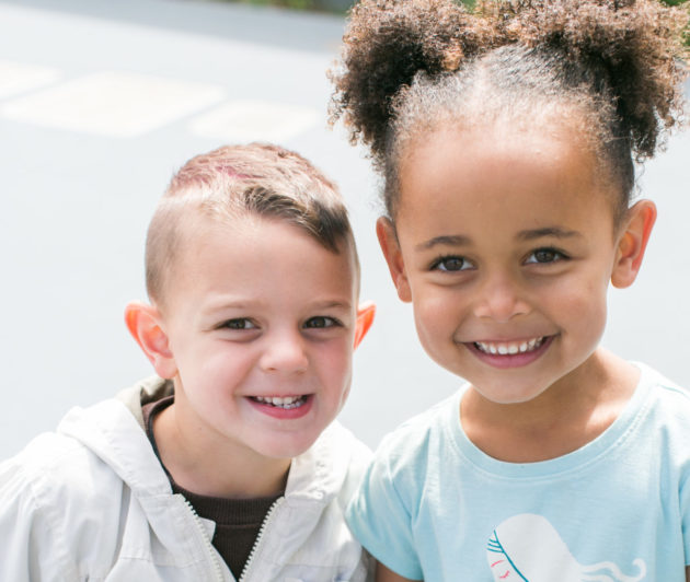 Brotherhood Way Preschool kids smiling on the playground.