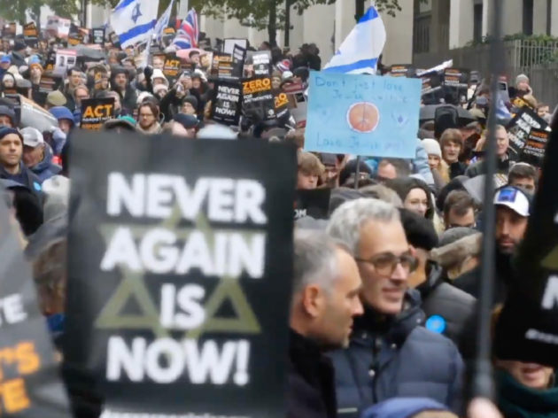 Image of people gathering and marching down a city street.