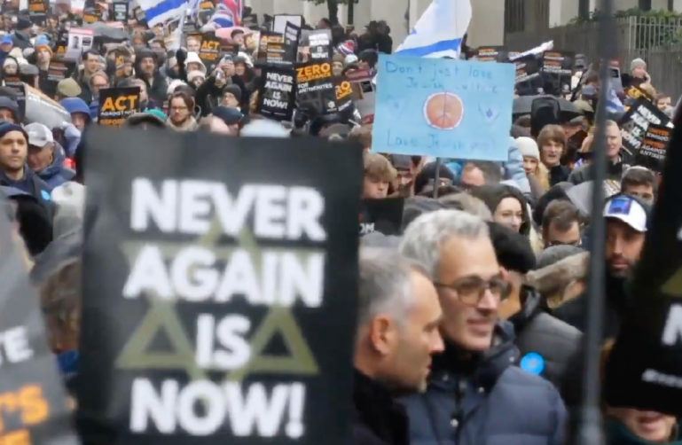Image of people gathering and marching down a city street.